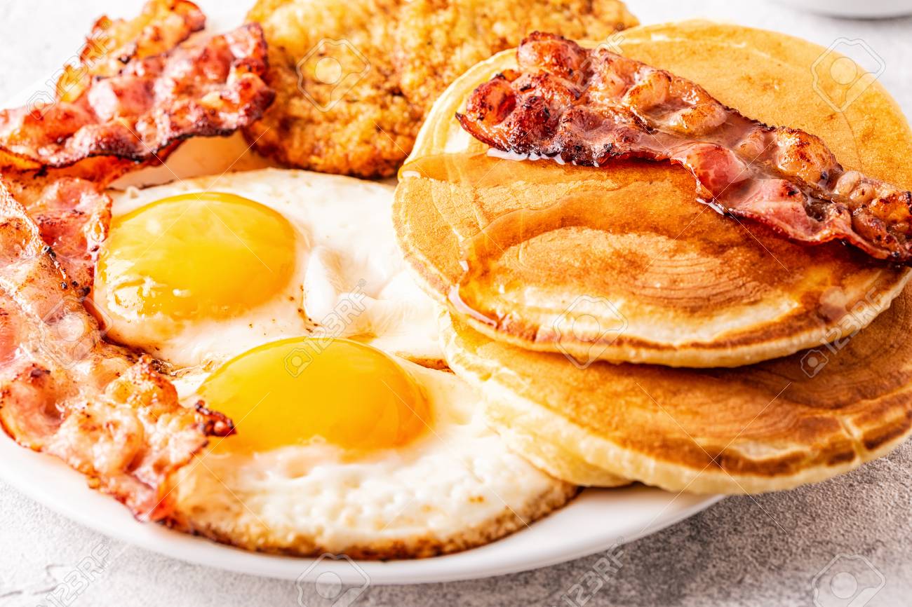 Healthy Full American Breakfast with Eggs Bacon Pancakes and Latkes, selective focus. - 114331673 Healthy Full American Breakfast with Eggs Bacon Pancakes and Latkes, selective focus. - 114331673