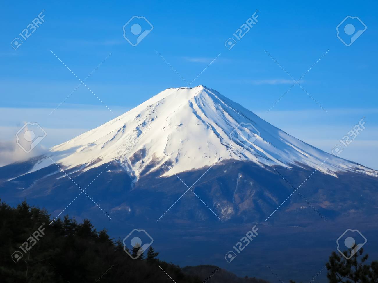 fuji mountain top filled with white snow and blue sky background
