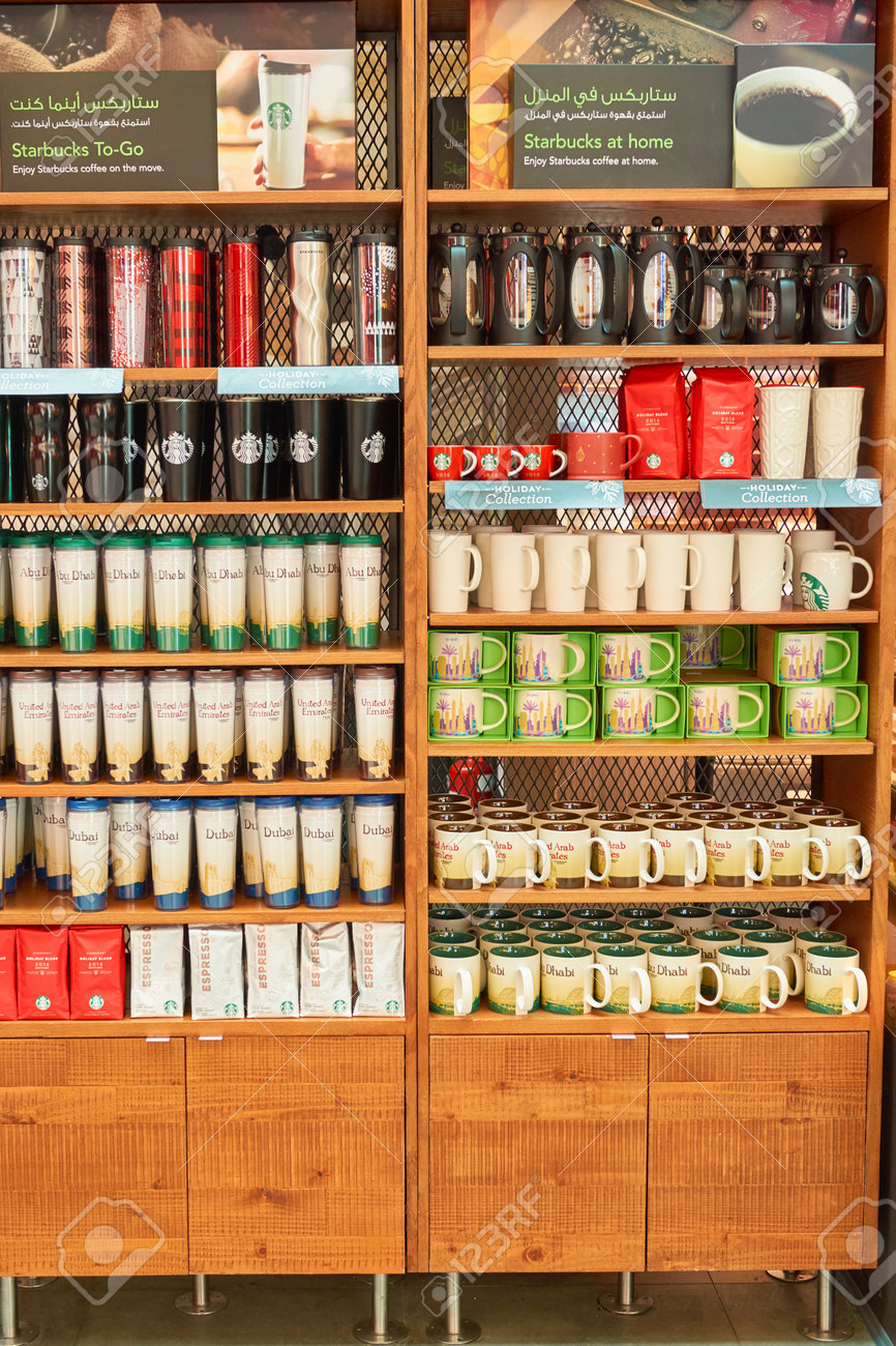 두바이 - 2016 년 11 월 11 일 : 두바이 국제 공항의 스타 벅스 카페에서 컵과 함께 선반. Starbucks  Corporation은 미국의 커피 회사이자 커피 하우스 체인입니다. 로열티 무료 사진, 그림, 이미지 그리고