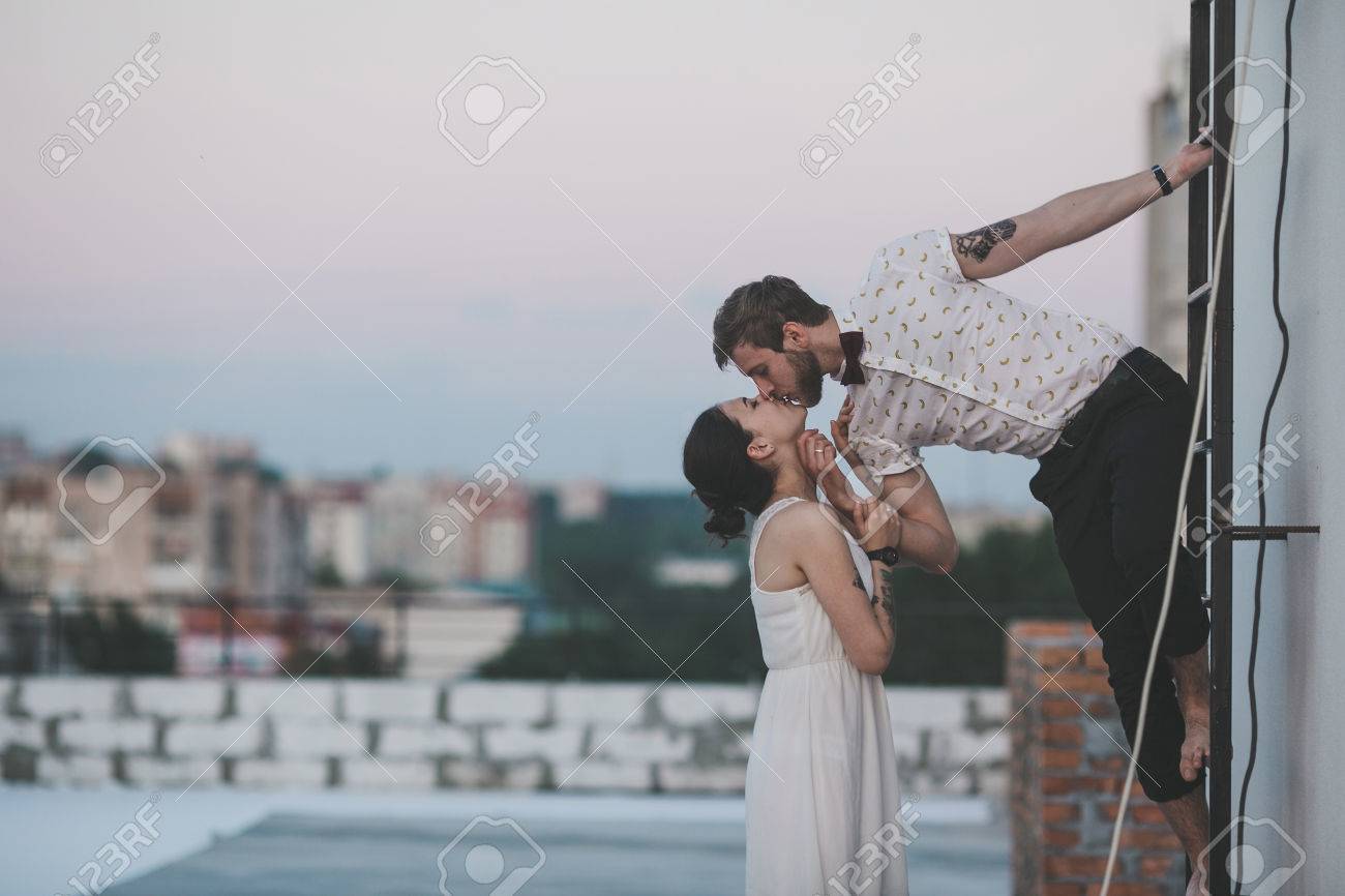 beautiful couple together on the roof of a tall building - 39036650 beautiful couple together on the roof of a tall building - 39036650