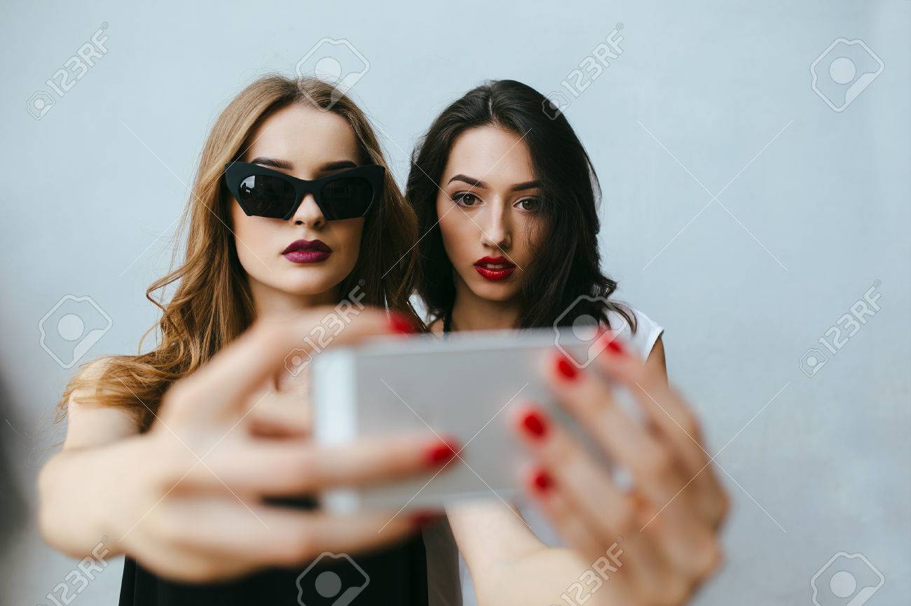 Two teenage girlfriends taking a selfie with smartphone - 44751623 Two teenage girlfriends taking a selfie with smartphone - 44751623