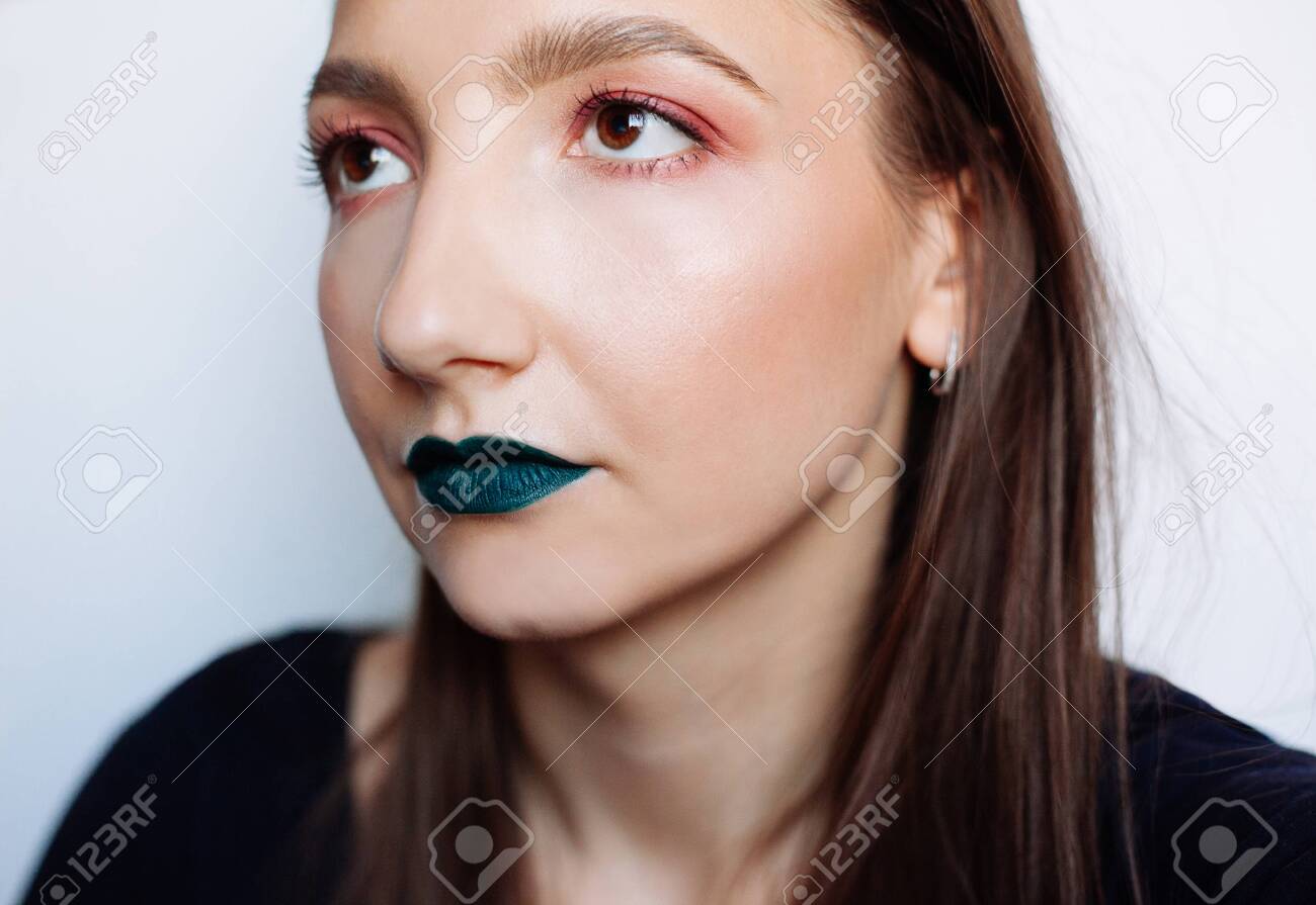 Close up selfie portrait of pretty young brunette with creative make up: green ilpstick and red eyeshadows - 122133924 Close up selfie portrait of pretty young brunette with creative make up: green ilpstick and red eyeshadows - 122133924