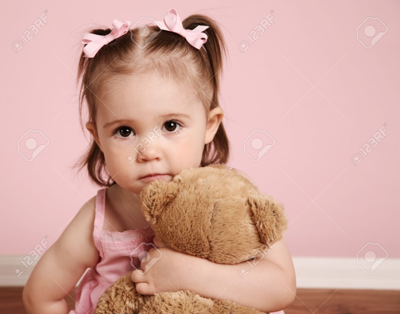 Portrait of an adorable toddler girl hugging a teddy bear on a vintage pink background - 8710185 Portrait of an adorable toddler girl hugging a teddy bear on a vintage pink background - 8710185