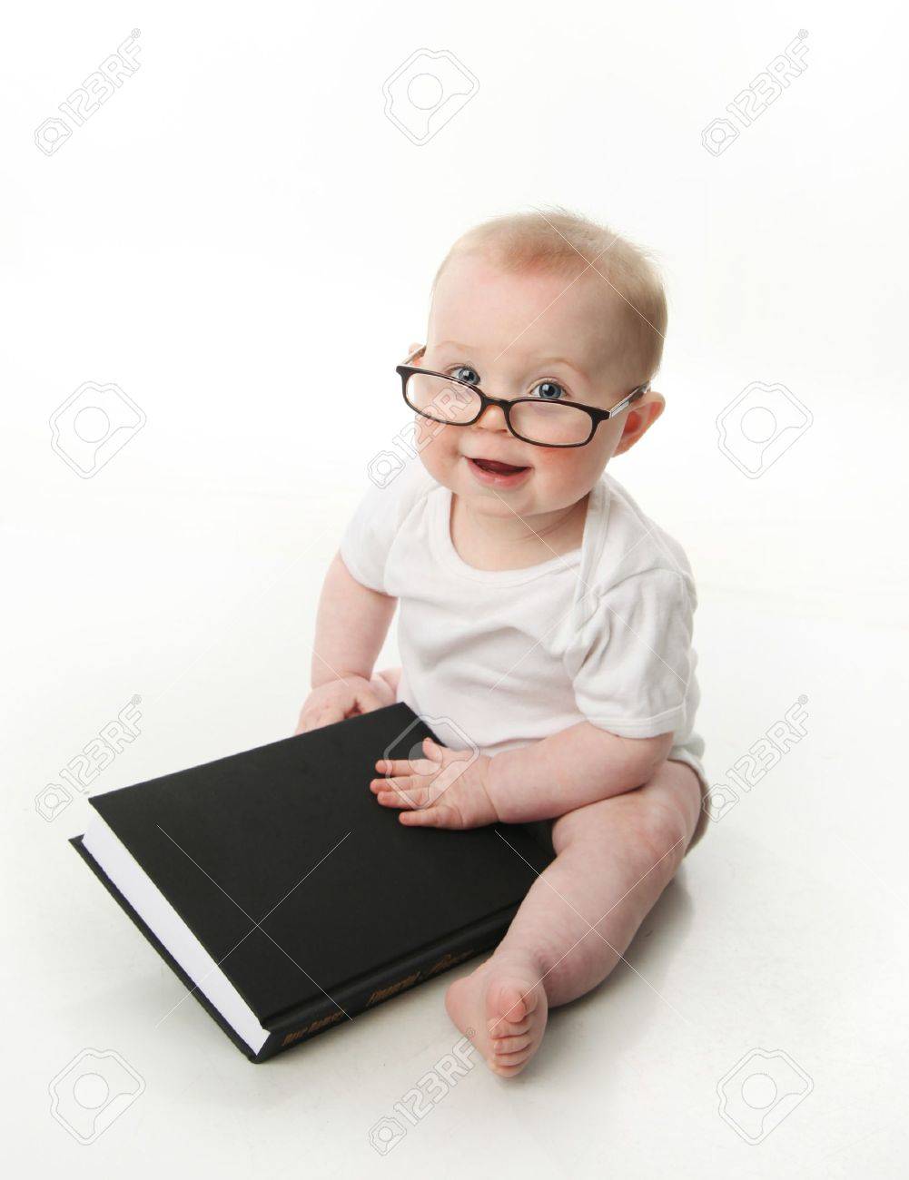 Portrait of an adorable baby sitting up wearing eyeglasses and looking at a book, isolated on white - 9939636 Portrait of an adorable baby sitting up wearing eyeglasses and looking at a book, isolated on white - 9939636