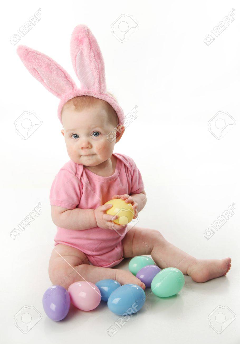 Portrait of a cute baby dressed in Easter bunny ears with a basket full of eggs - 9939701 Portrait of a cute baby dressed in Easter bunny ears with a basket full of eggs - 9939701