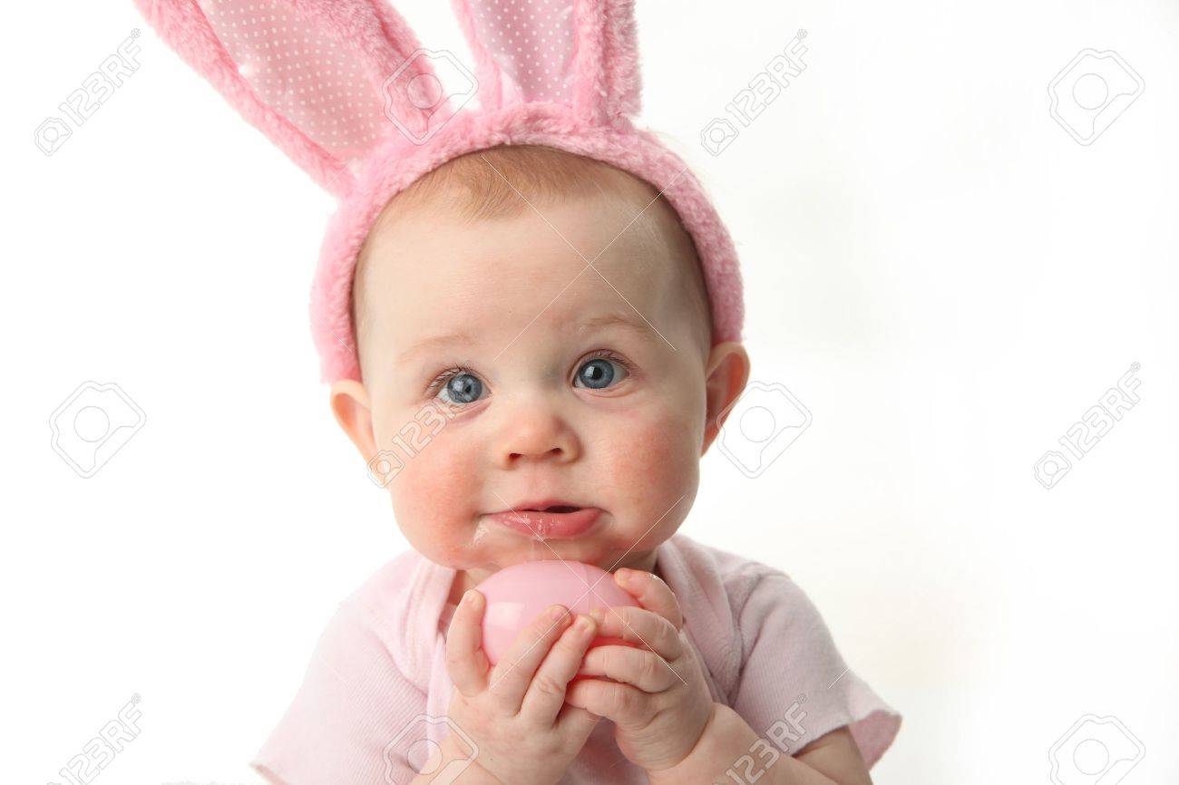 Portrait of a cute baby dressed in Easter bunny ears pastel eggs - 9939664 Portrait of a cute baby dressed in Easter bunny ears pastel eggs - 9939664