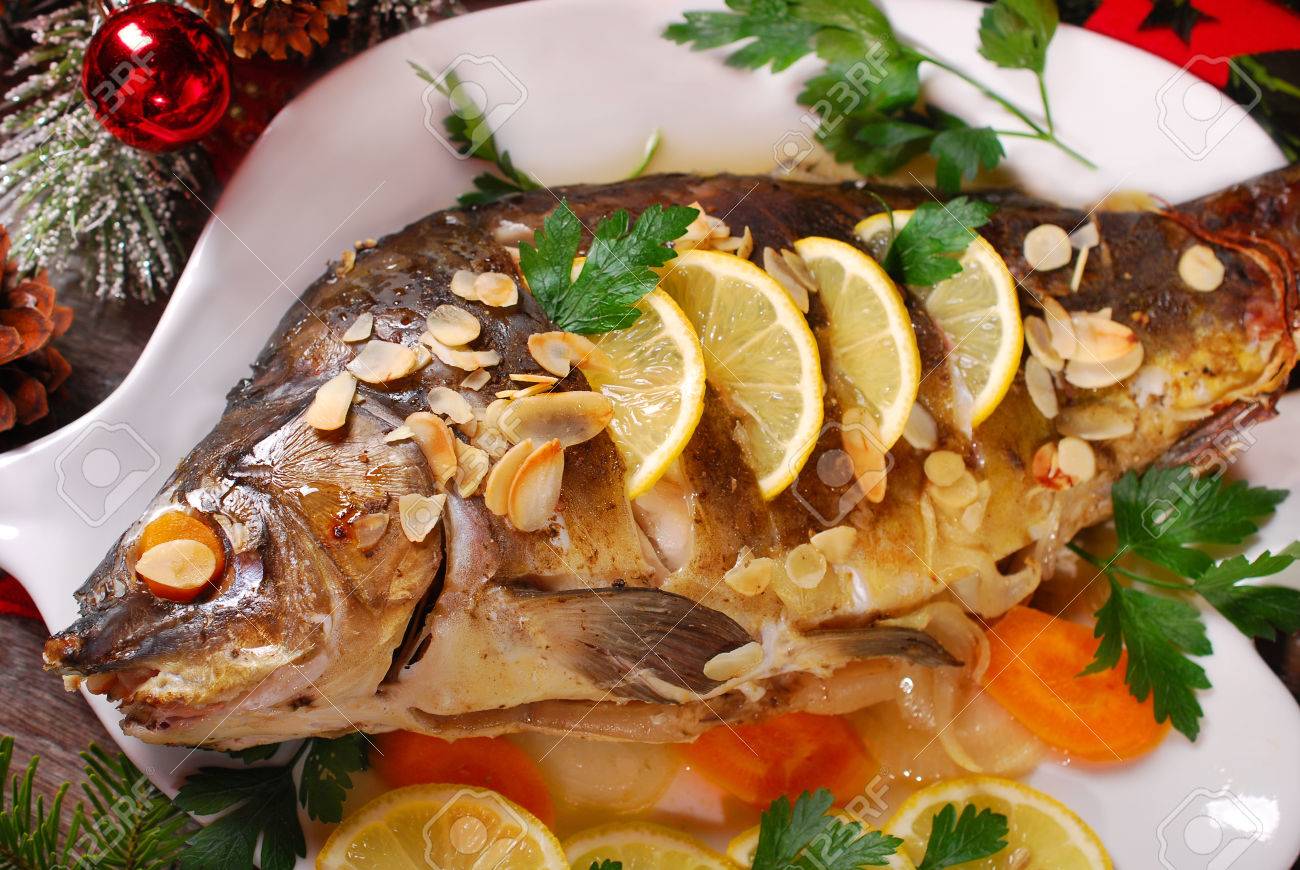 roasted whole carp stuffed with vegetables and almonds on wooden table for christmas - 34558555 roasted whole carp stuffed with vegetables and almonds on wooden table for christmas - 34558555