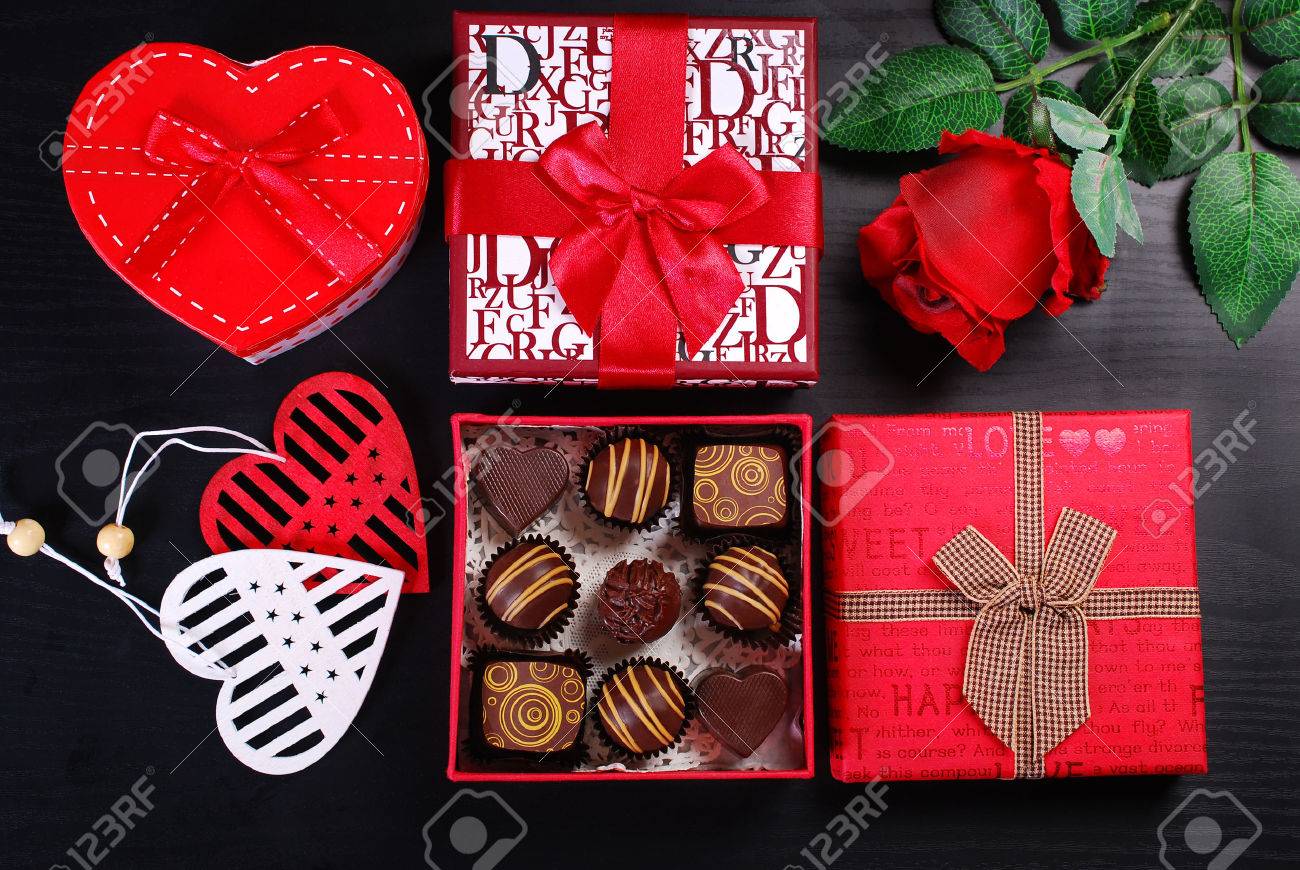 red gift boxes with chocolate pralines and rose on black background for valentines day - 52549194 red gift boxes with chocolate pralines and rose on black background for valentines day - 52549194