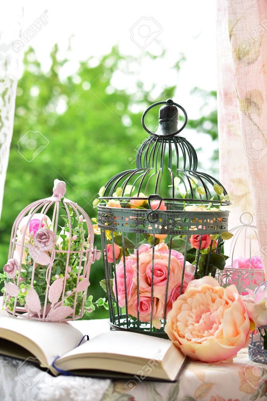 Décoration De Style Vintage Avec Journal Ouvert Et Cages Doiseaux En Métal Avec Des Fleurs Sur La Table De Jardin