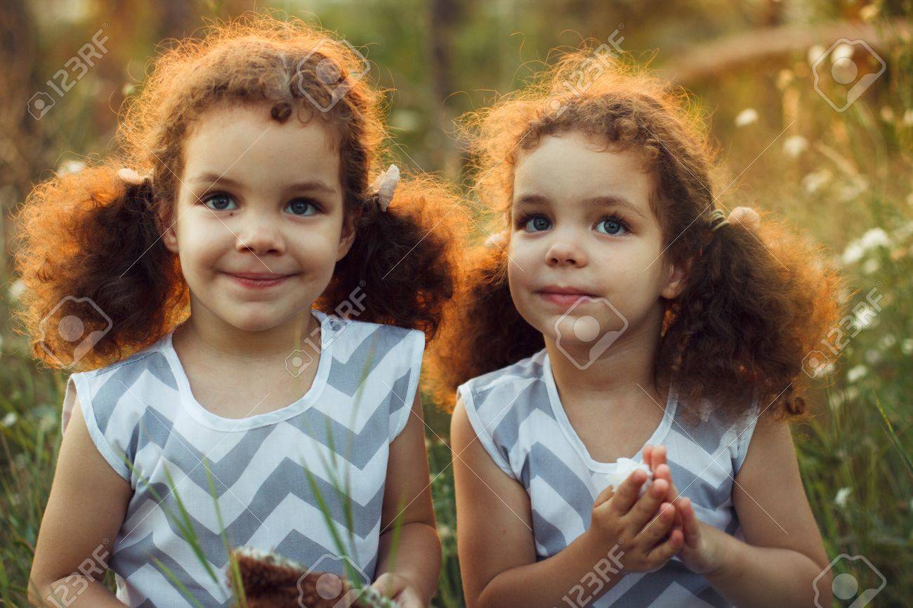 姉妹は双子幼児キスをし 真夏の野外で笑っています カーリーのかわいい女の子 幼年期の友情 暖かい Sunligh の写真素材 画像素材 Image