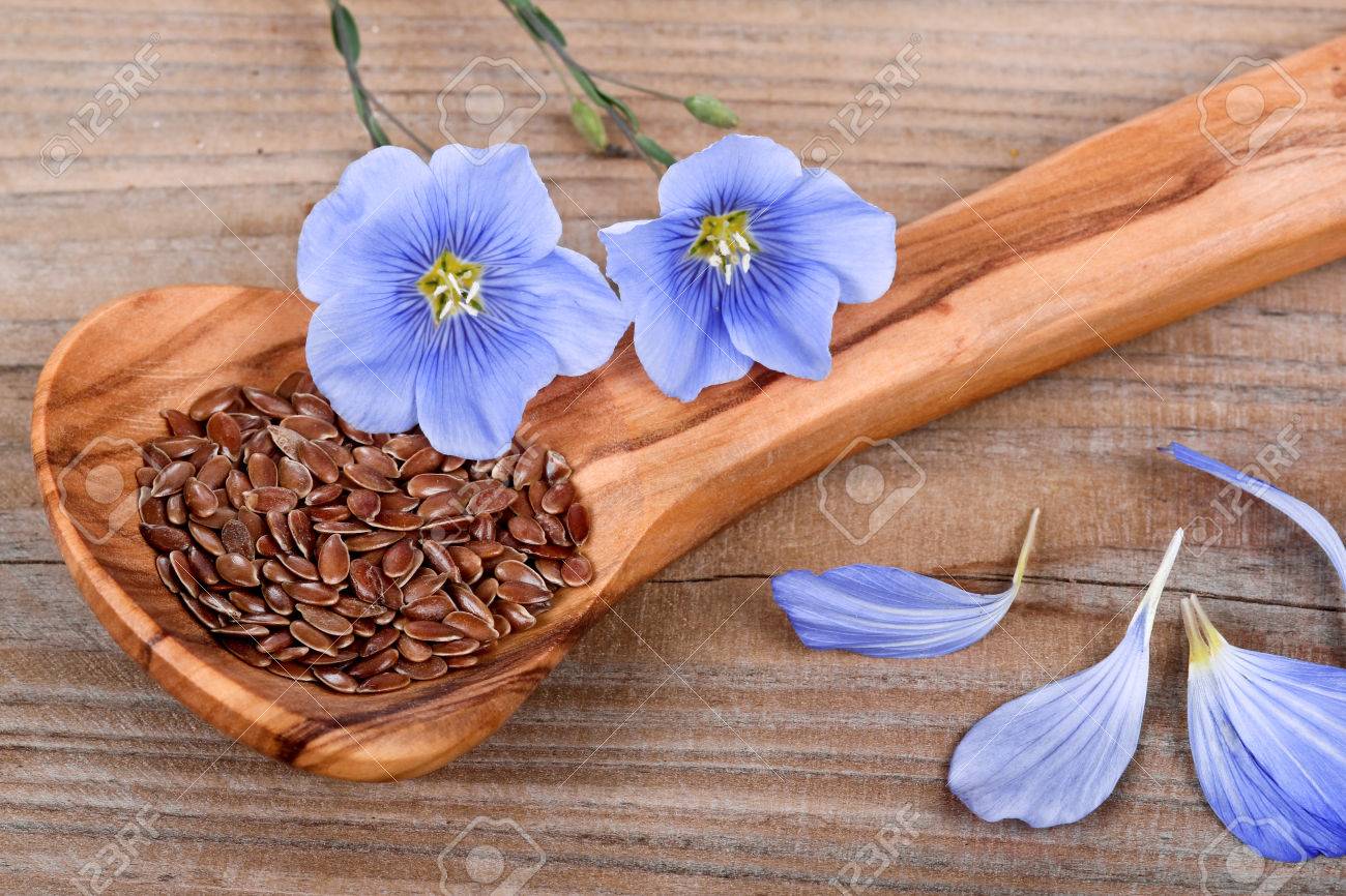 Wooden spoon with flaxseed and linum blossoms - 32926509 Wooden spoon with flaxseed and linum blossoms - 32926509
