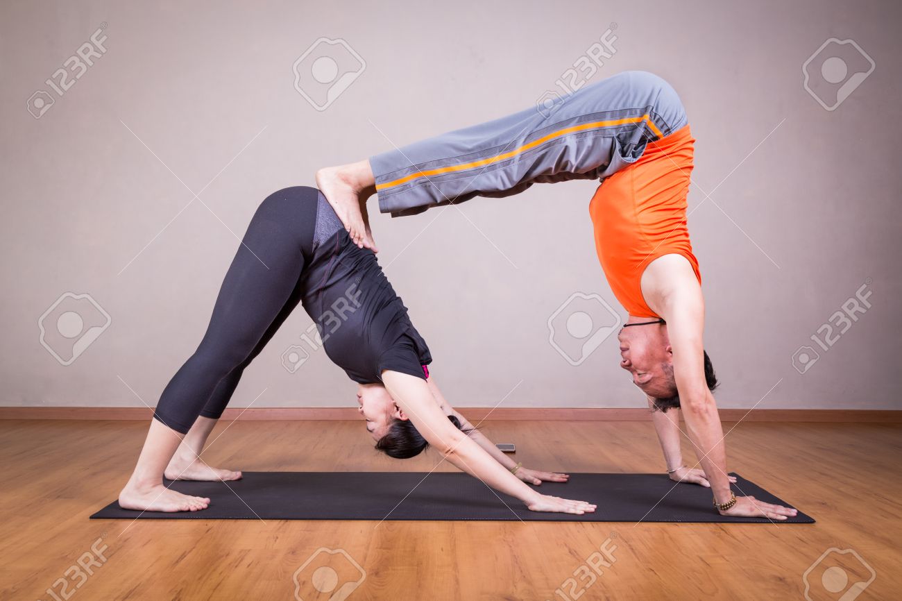 Partner Yoga Pose Of Double Downward Dog By A Couple Within A