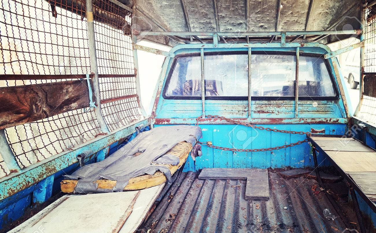 Old Mattress Place Behind Back Of Blue Pickup Truck In Vintage