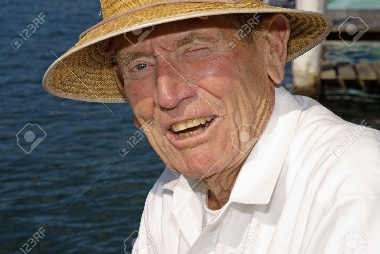 Elderly man with sun hat at waters edge - 9385779 Elderly man with sun hat at waters edge - 9385779
