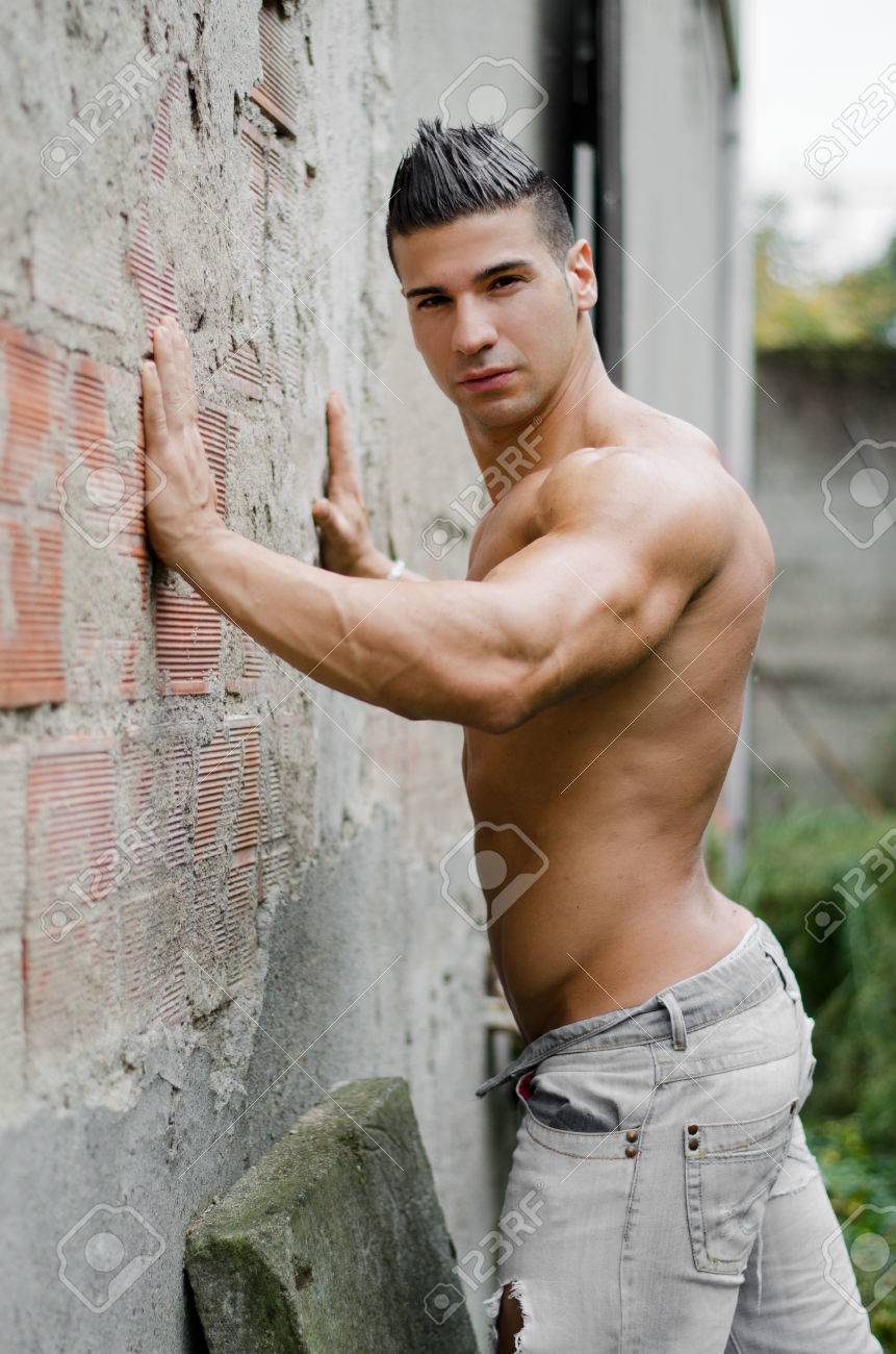 24531851-muscular-young-latino-man-shirtless-in-jeans-leaning-against-concrete-wall-looking-at-camera-Stock-Photo.jpg
