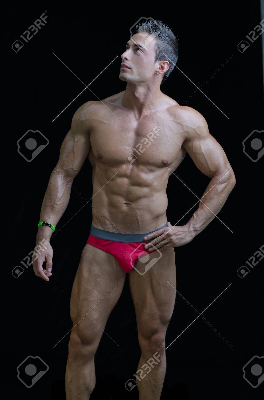 筋肉若いボディービルダー リラックスしたポーズで 側を見上げています 黒に分離 の写真素材 画像素材 Image