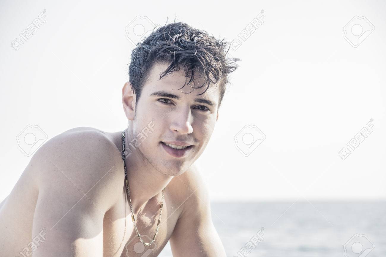 カメラで見て濡れた髪と水の出る海の魅力的な若い男 の写真素材 画像素材 Image