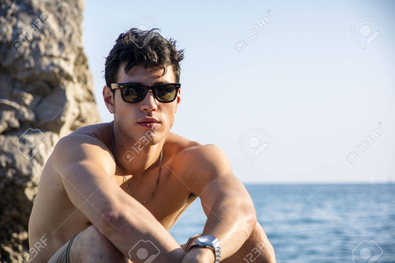 海の水と濡れた髪から抜け出す カメラで探して サングラスを押し上げ カメラに笑顔で魅力的な若い男 の写真素材 画像素材 Image