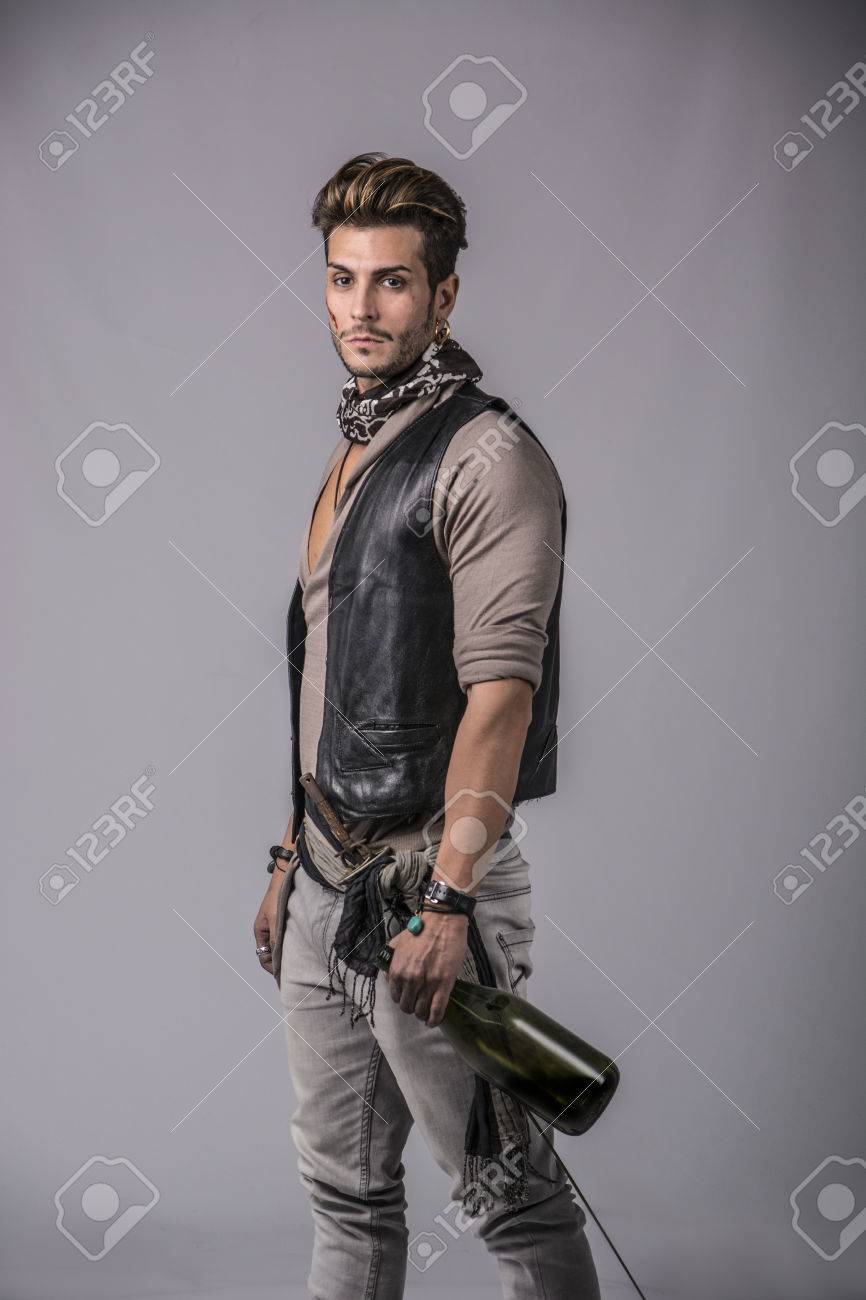 灰色の背景に海賊ファッション衣装で良い探している若い男 スタジオでキャプチャされます の写真素材 画像素材 Image