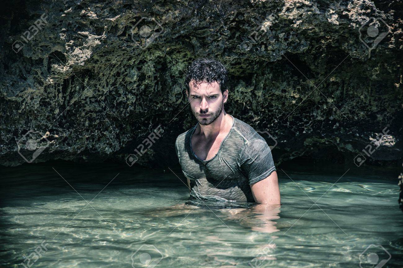 Привлекательный Молодой Спортивный Человек В Море Или Океане Скалистом  Берегу, Носить Мокрые Футболки, СЭУС Выражение Фотография, картинки,  изображения и сток-фотография без роялти. Image 53443590