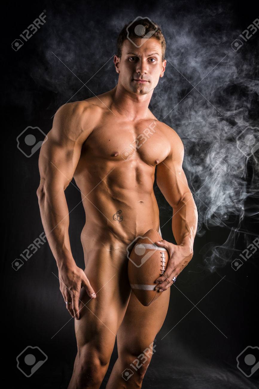 Culturiste Cacher Les Organes Génitaux Masculins Totalement Nue Avec Ballon  De Football Américain, Regardant La Caméra, Sur Fond Sombre Banque D'Images  et Photos Libres De Droits. Image 69846916