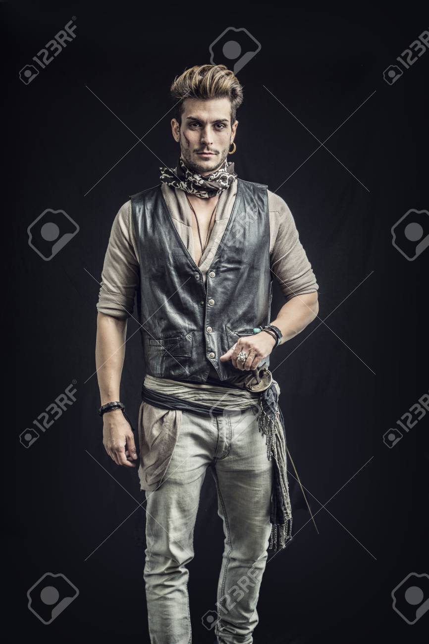 灰色の背景に海賊ファッション衣装で良い探している若い男 スタジオでキャプチャされます の写真素材 画像素材 Image