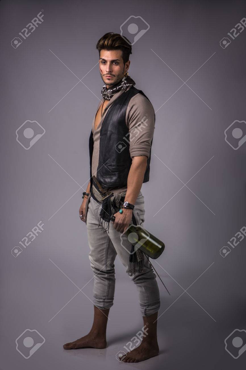 Good Looking Young Man in Pirate Fashion Outfit on Gray Background. Captured in Studio. - 73481657 Good Looking Young Man in Pirate Fashion Outfit on Gray Background. Captured in Studio. - 73481657
