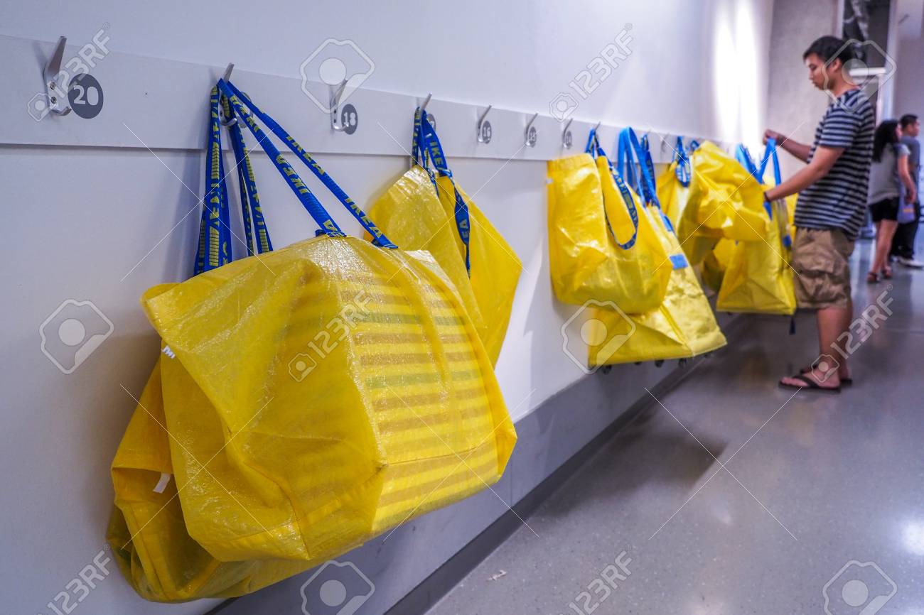 big yellow shopping bags in the ikea store hanging on the white