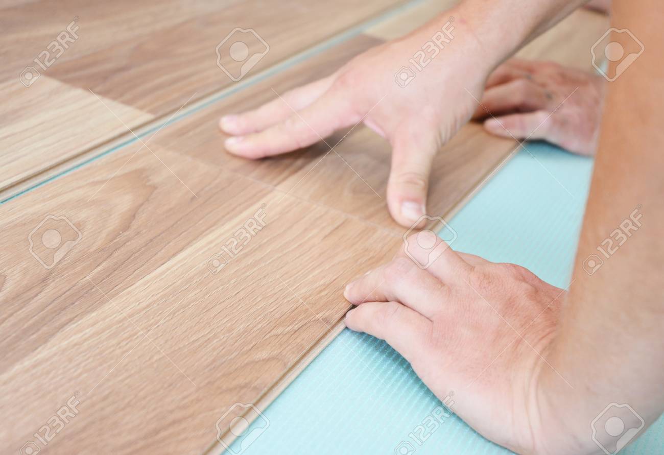 Contractor Installing Wooden Laminate Flooring With Insulation