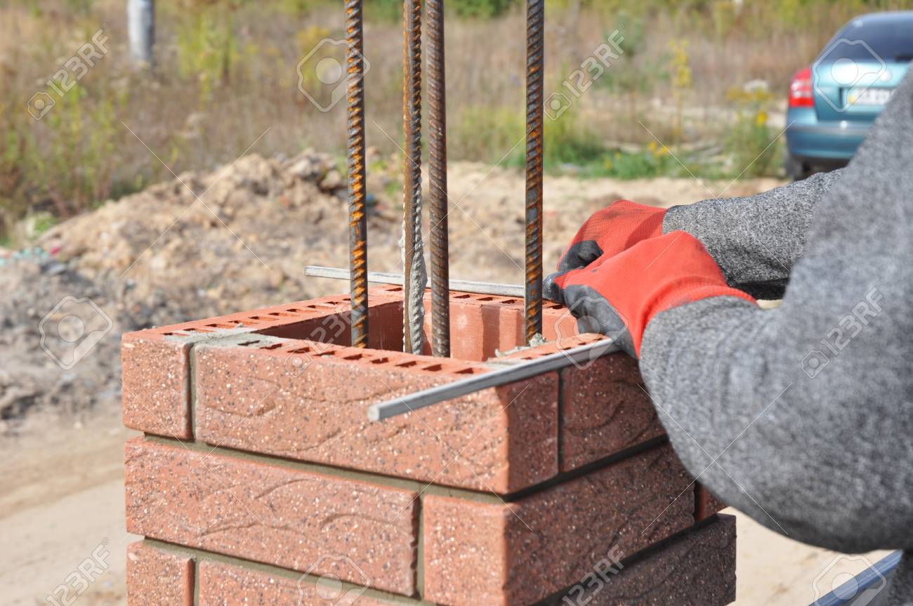 closeup on brick laying blocks correctly on fence brick column build column