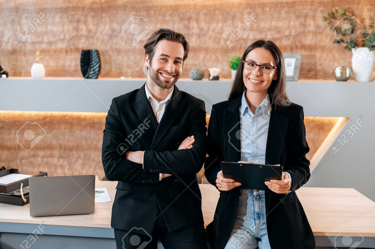 Retrato, de, dois, caucasiano, confiança, sucesso, empresa, empregados, colegas de negócio, um, homem, e, um, mulher, ficar, perto, a, desktop, em, um, escritório moderno, olhar, a, câmera, sorriso, amigável - 190229375 Retrato, de, dois, caucasiano, confiança, sucesso, empresa, empregados, colegas de negócio, um, homem, e, um, mulher, ficar, perto, a, desktop, em, um, escritório moderno, olhar, a, câmera, sorriso, amigável - 190229375