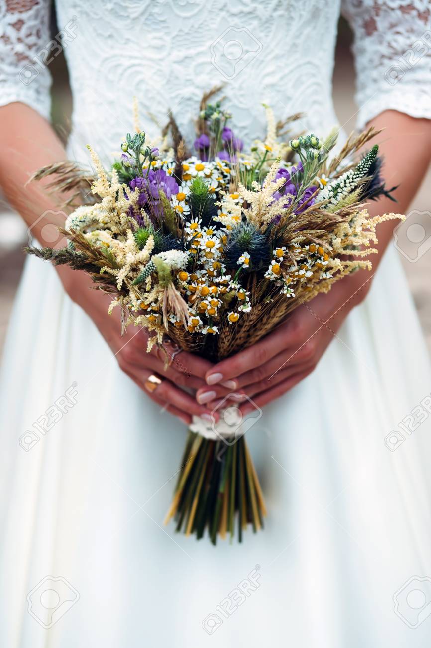 Bouquet De Fleurs Séchées Dans Les Mains De La Mariée Habillée Robe De Mariée Blanche