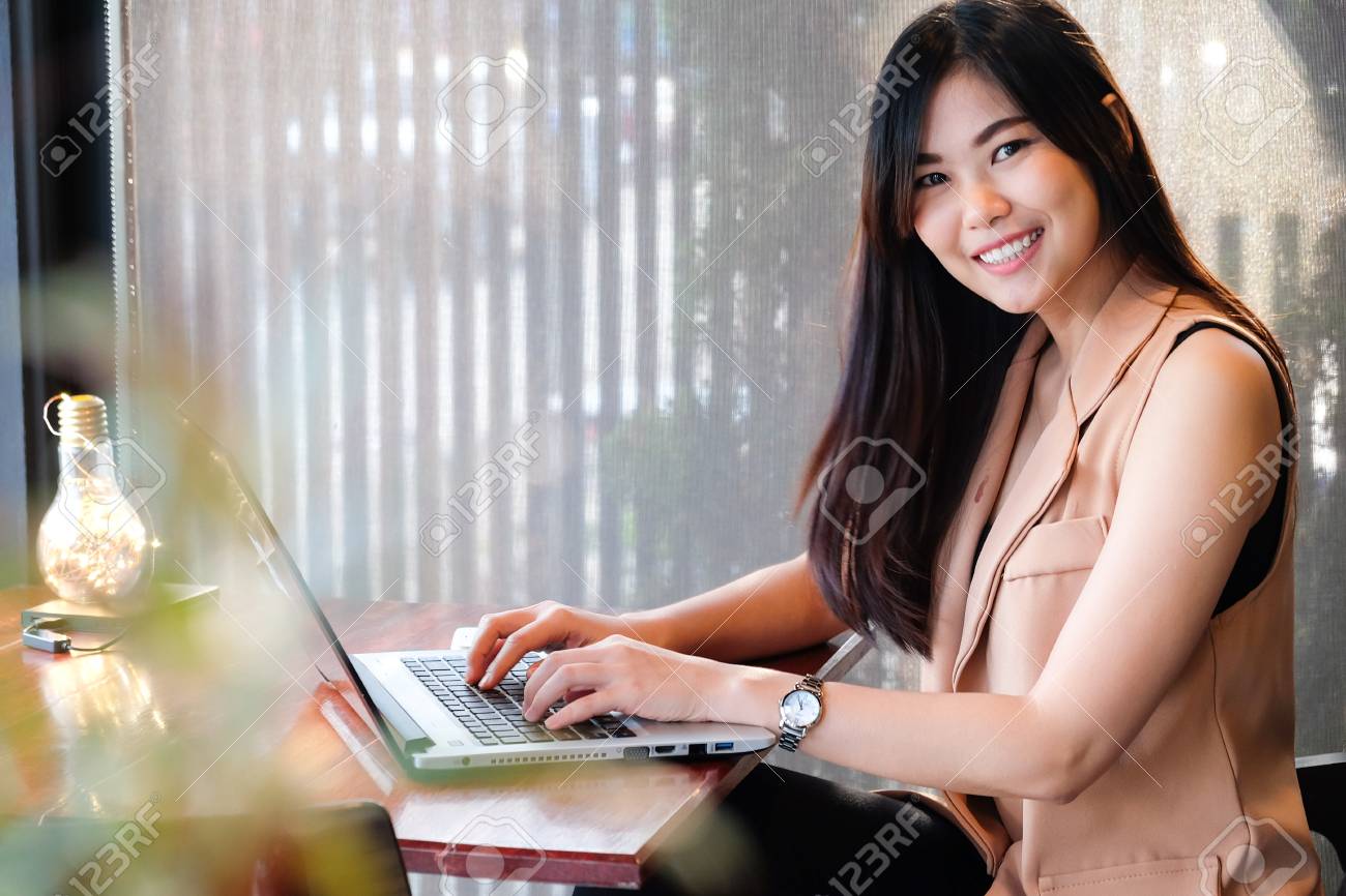 アジア ビジネス女性のモダンなコーヒー ショップでノート パソコンを使用してカジュアルなフリーランスの女性 の写真素材 画像素材 Image