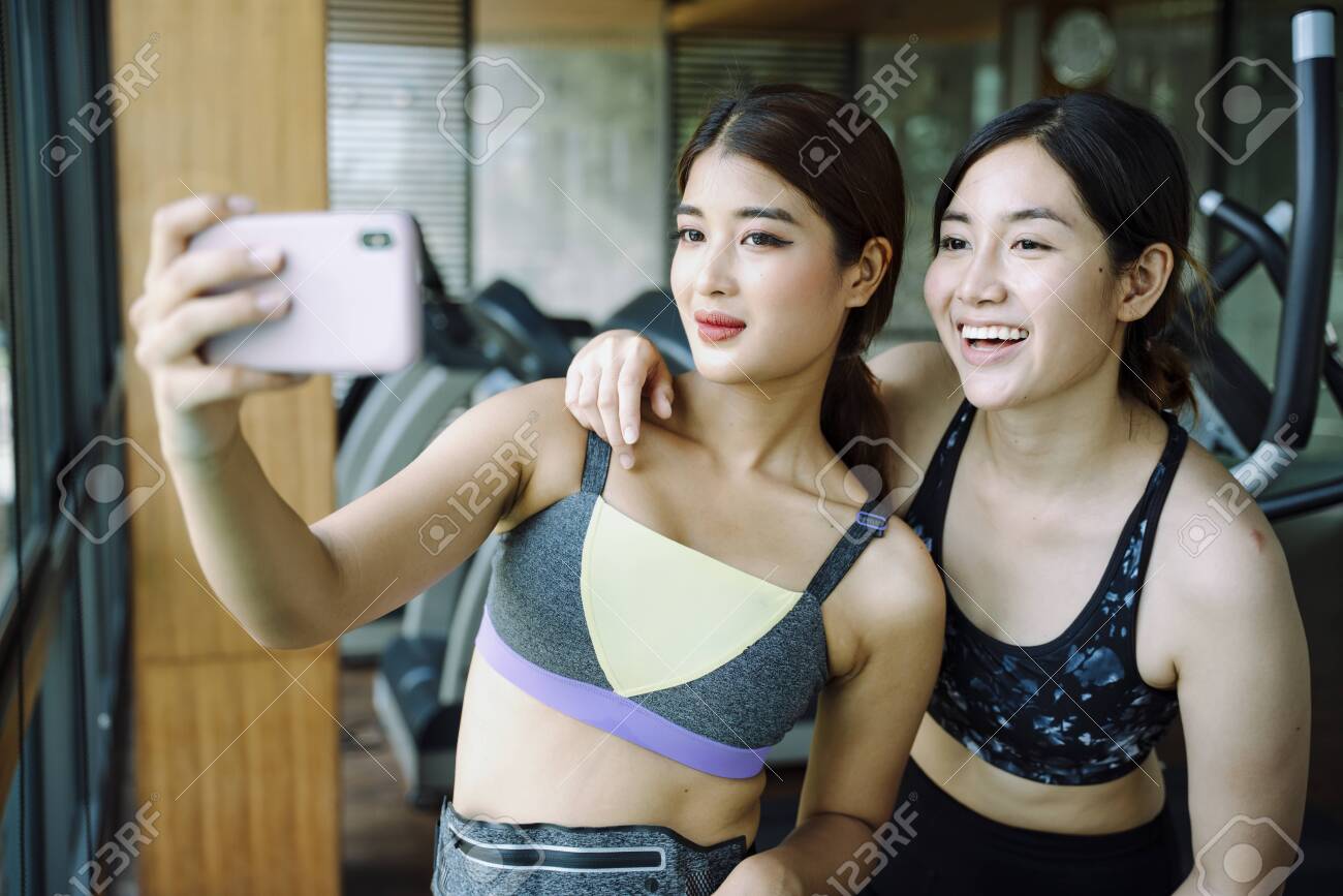 スポーツブラ 自撮り 美しい健康な女性は、ジムでスマートフォンで自分撮りをしているスポーツブラを着用しています。の写真素材・画像素材 Image 156806750