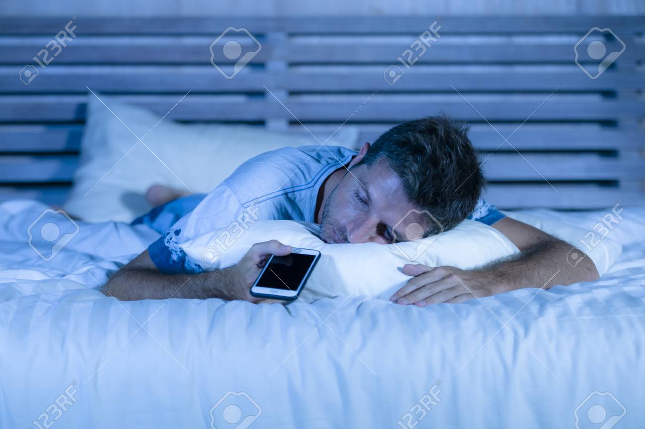 Young Attractive Tired Man In Bed Falling Asleep While Using Stock Photo Picture And Royalty Free Image Image 100376750