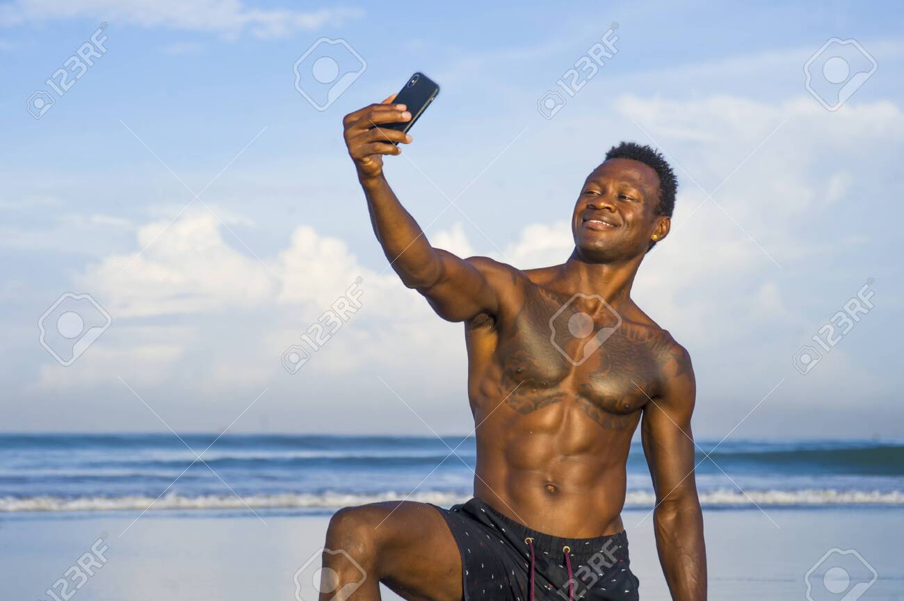 Young Attractive And Happy Black African American Sport Man With Athletic  Body And Sixpack Taking Selfie Photo With Mobile Phone At Beautiful Beach  Smiling Cool In Holidays And Travel Concept Stock Photo,, image size:1300x865