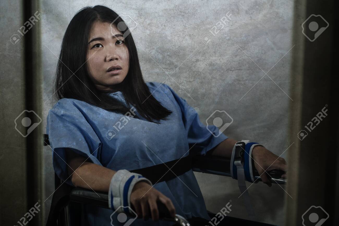 Young Crazy And Mentally Insane Asian Woman Restrained In Wheelchair At  Mental Hospital Suffering Psychiatric Disorder As Schizophrenia Looking  Catatonic In Korean Horror Movie Style Stock Photo, Picture and Royalty  Free Image.