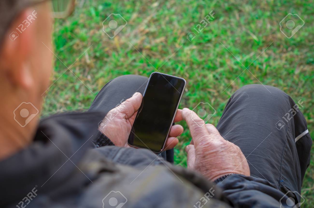 Close up of a wrinkled finger touching the smartphone, old man uses technology. Internet. - 98191500 Close up of a wrinkled finger touching the smartphone, old man uses technology. Internet. - 98191500