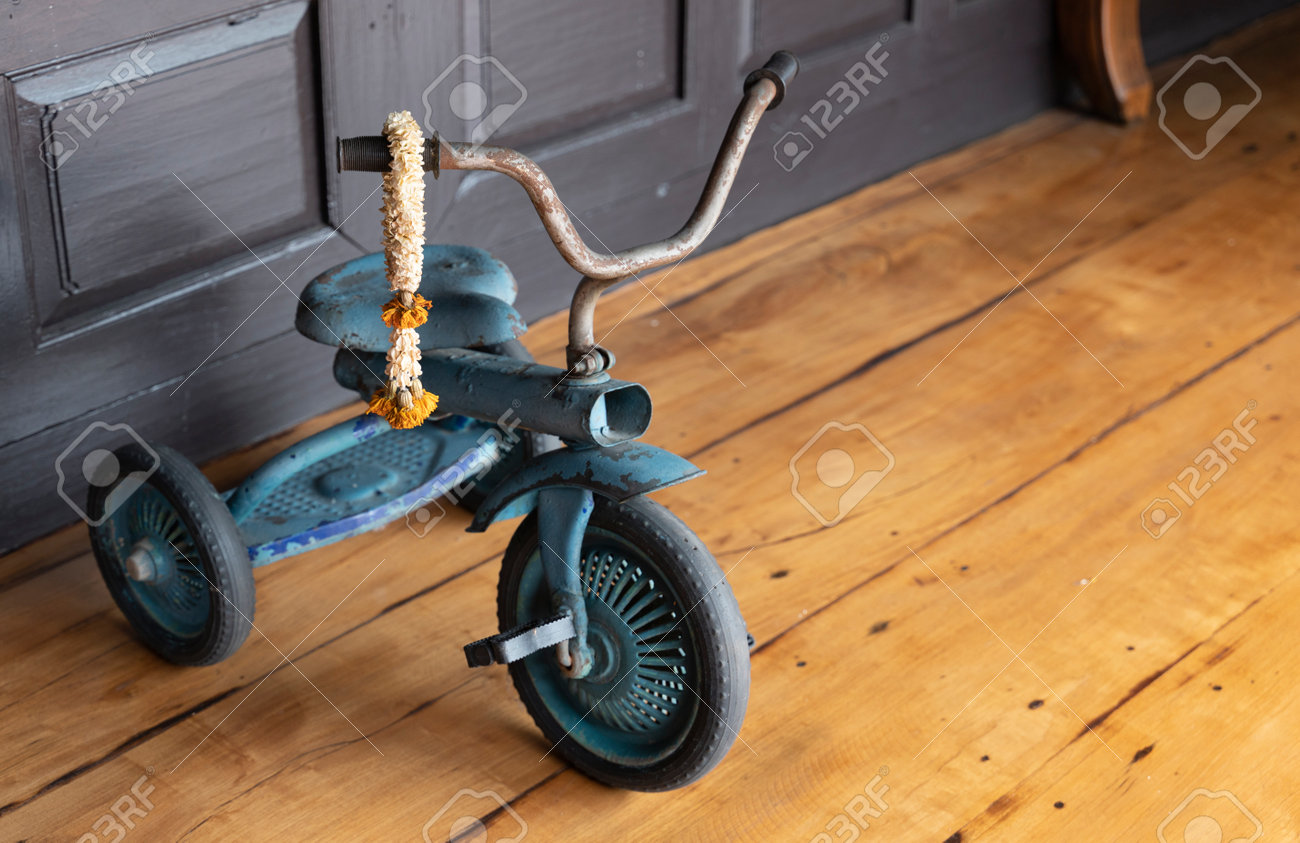 ビンテージ 木製三輪車 壊れて錆びたビンテージの三輪車が木の床に空