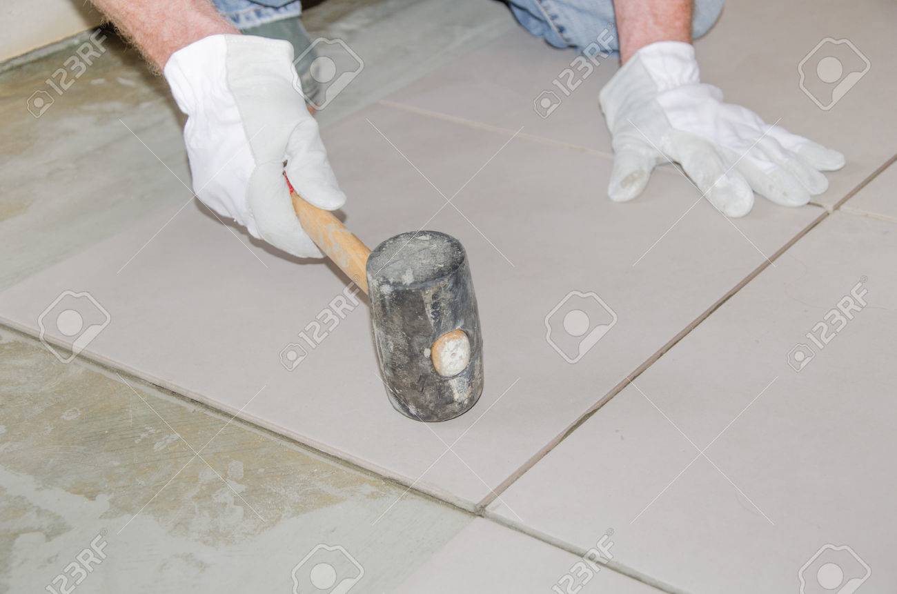 Laying Floor Tiles Tiler Using A Rubber Mallet Stock Photo