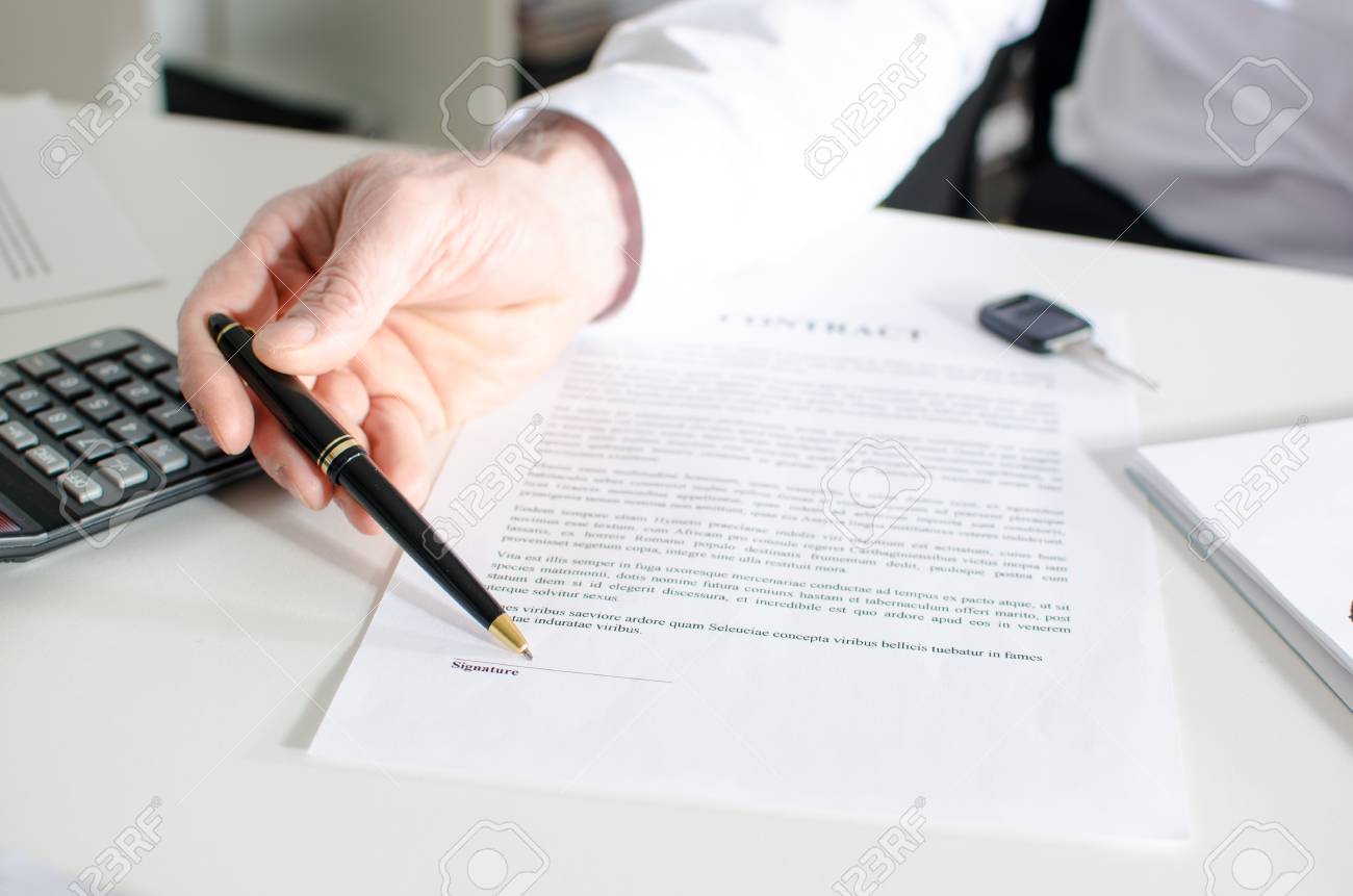 car salesman showing a sales contract at office stock photo picture