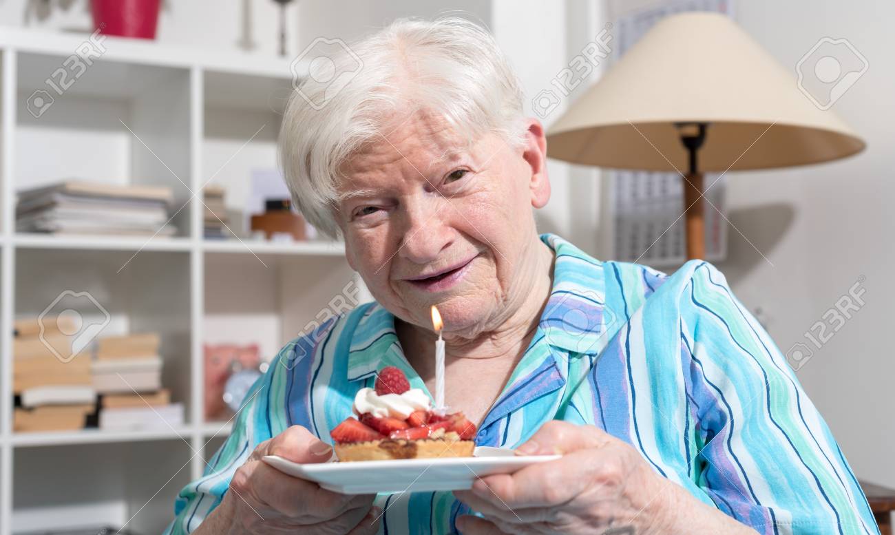 Portrait Of A Happy Old Woman Holding A Little Birthday Cake Stock Photo Picture And Royalty Free Image Image