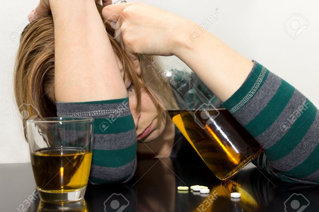 Drunk woman with bottle in her hand and pills on the table - 25905007 Drunk woman with bottle in her hand and pills on the table - 25905007