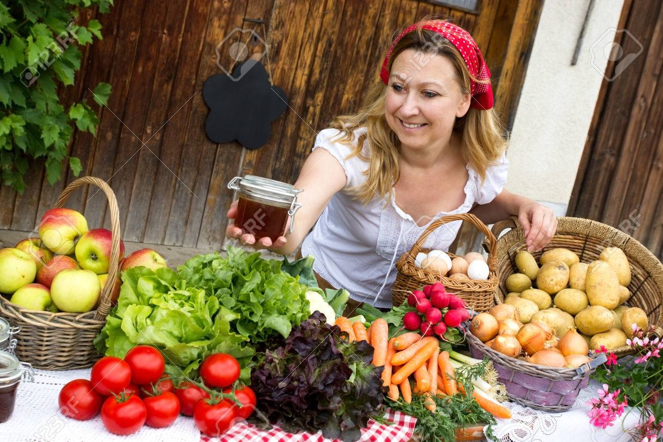 A cute marketwoman offers honey at the market - 61705999 A cute marketwoman offers honey at the market - 61705999