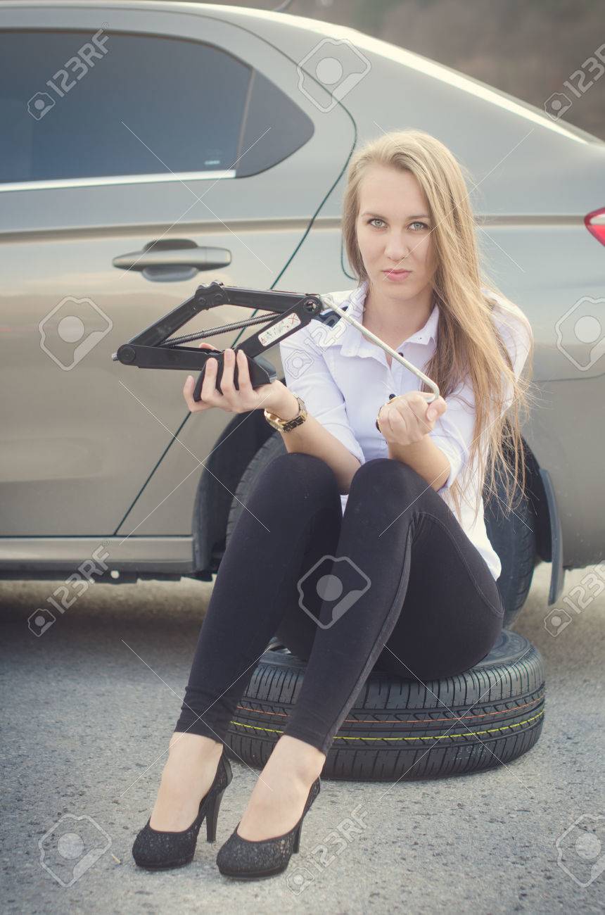 少女は思った 背景に壊れた車 ホイールの女性座る セクシーな若い女性は 車を修復します 自然な背景 車の事故 の写真素材 画像素材 Image