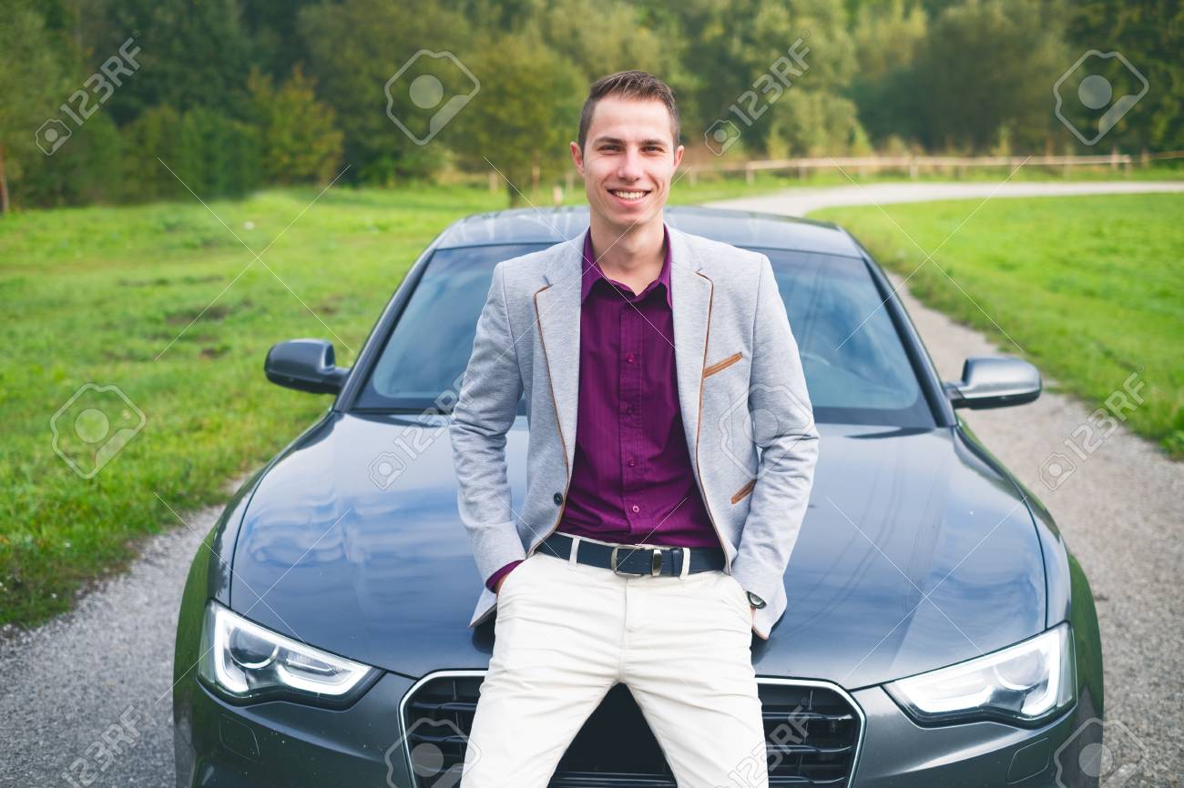 若い 幸せな 車の中のビジネスマン 高価なスポーツカーのそばに立っているスーツを着た男 成功した若者 の写真素材 画像素材 Image