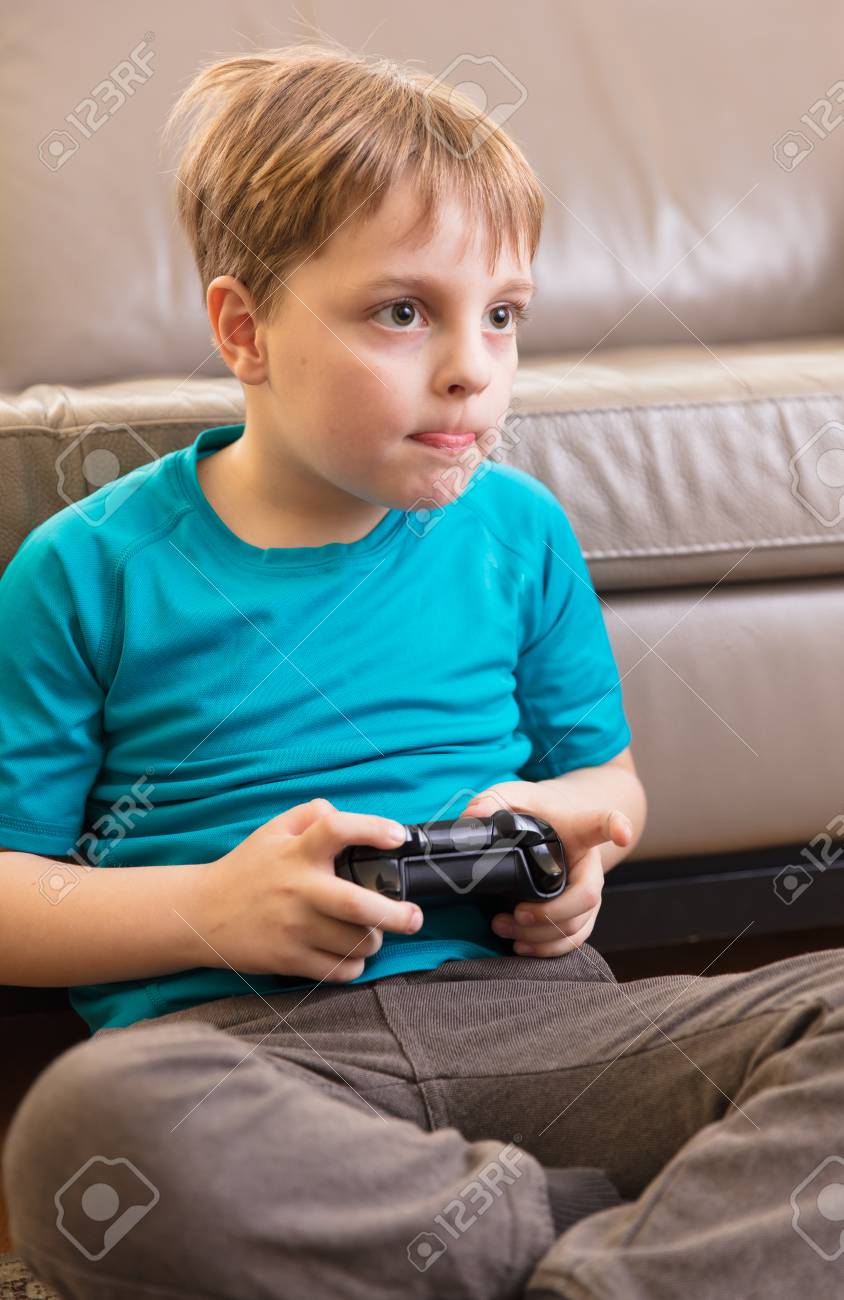 Banque Dimages Little Boy Playing Some Video Games At Home Using A Controller Making Different Expressions Banque Dimages Little Boy Playing Some Video Games At Home Using A Controller Making Different Expressions