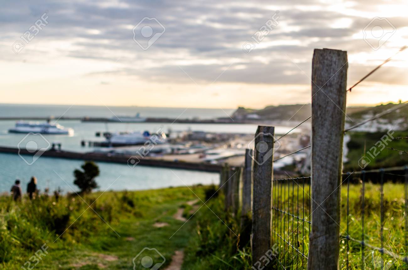 a countryside fence leading to a distant port port of dover