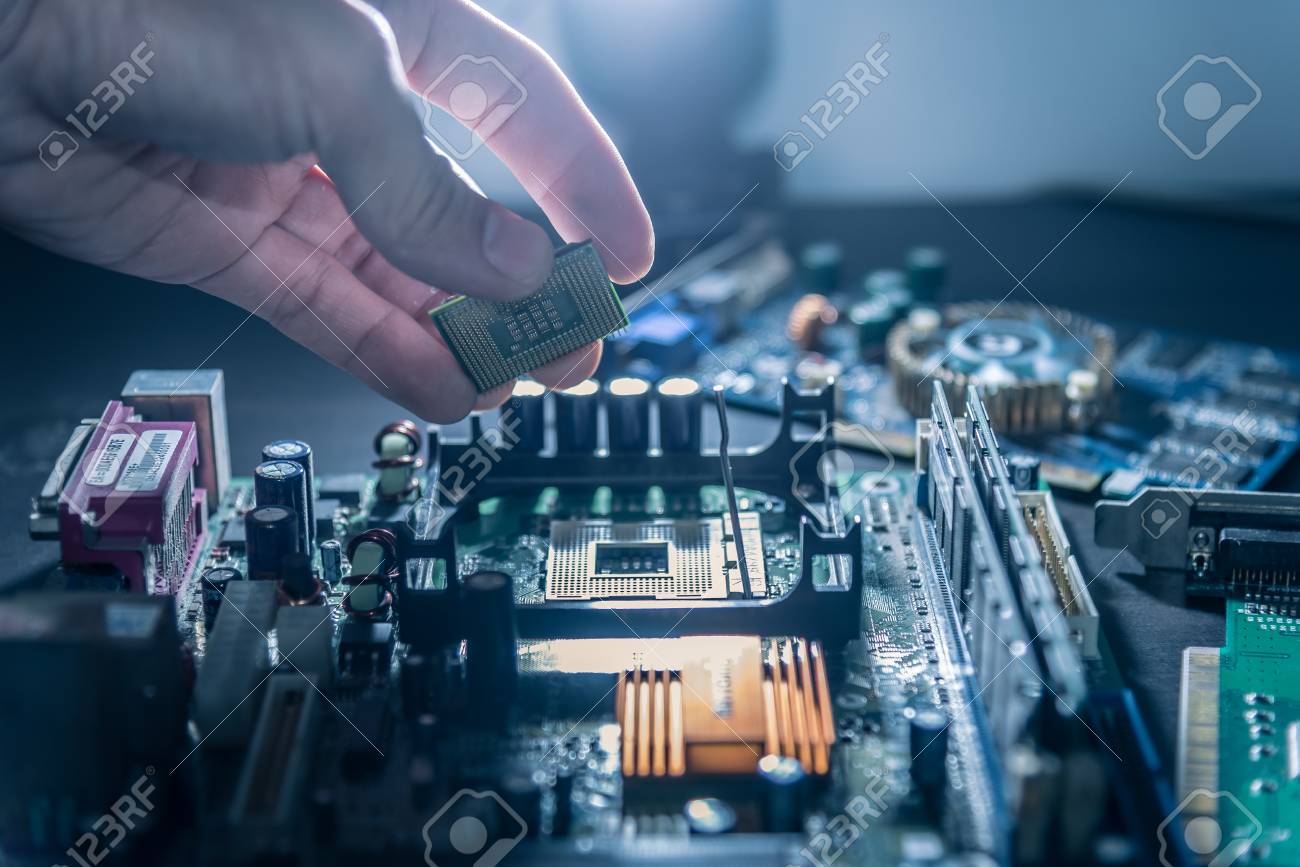 The technician is putting the CPU on the socket of the computer motherboard. - 93717860 The technician is putting the CPU on the socket of the computer motherboard. - 93717860