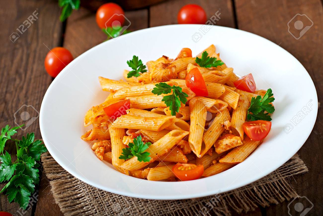 Penne Pasta In Tomato Sauce With Chicken Tomatoes On A Wooden Stock Photo Picture And Royalty Free Image Image 40011649